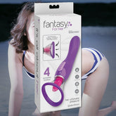 A purple silicone vibrator from Pipedream, named "Fantasy For Her 'Her Ultimate Pleasure' Licking & Sucking Sensation Vibrator," is highlighted in its packaging, emphasizing its "4 powerful motors" for customizable pleasure. This oral sex toy is designed for personalized satisfaction and stands out visually while a person in a striped swimsuit appears blurred in the background.
